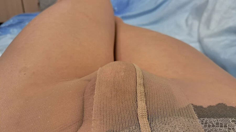 Image gallery: Man wearing transparent suntan pantyhose teasing with his legs on the bed